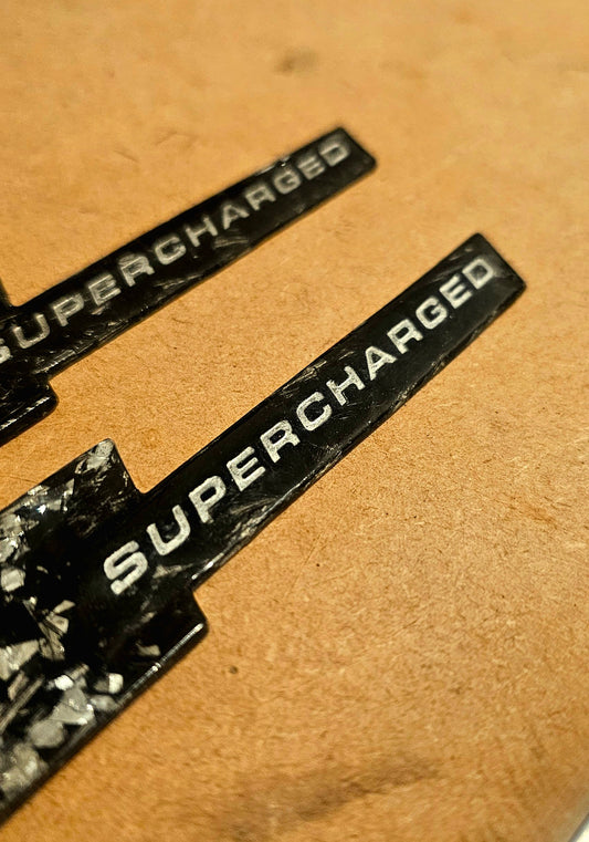 Forged carbon Audi supercharged wing badges pair